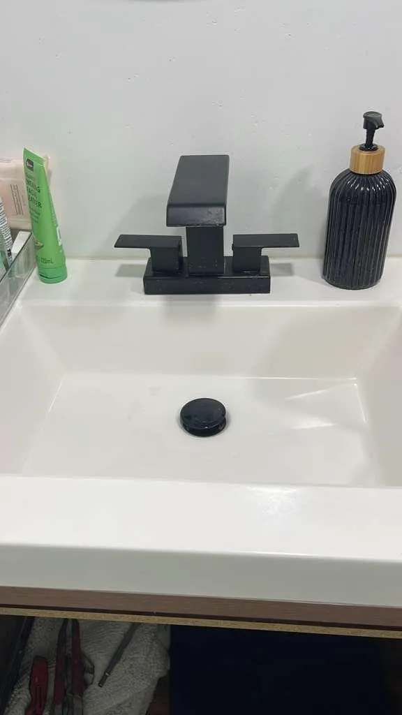 A matte black single-handle faucet newly mounted on a white vessel basin